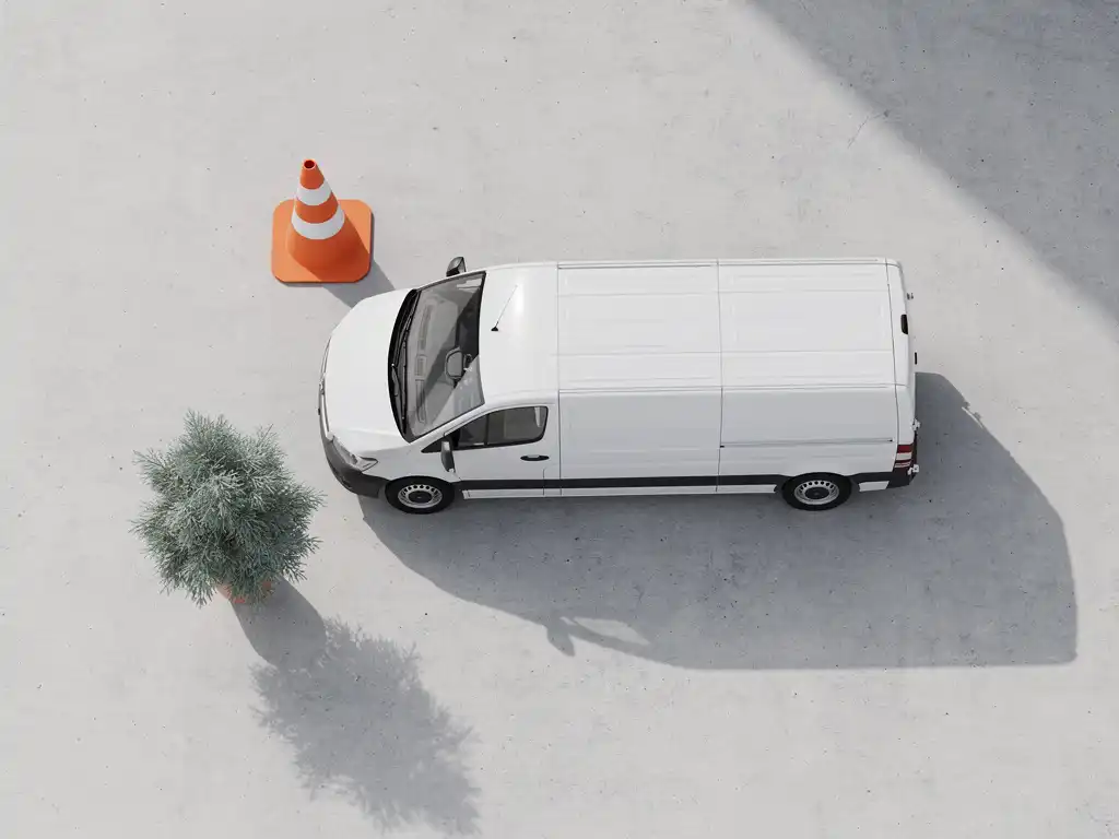Witte bestelwagen geparkeerd naast oranje verkeerskegel en groene plant in pot op betonnen ondergrond, bovenaanzicht
